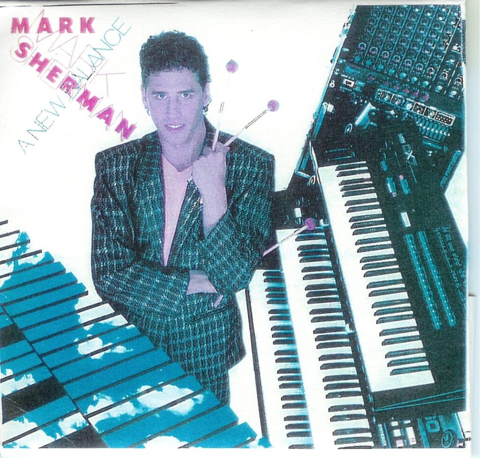 A man standing next to some keyboards and an organ