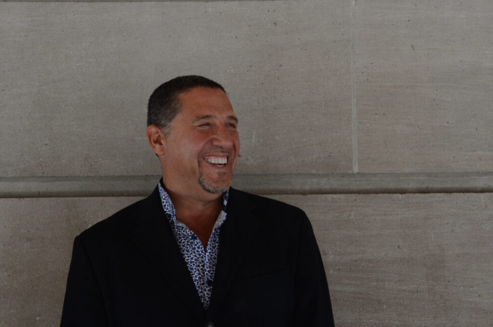 A man in a suit smiling for the camera.