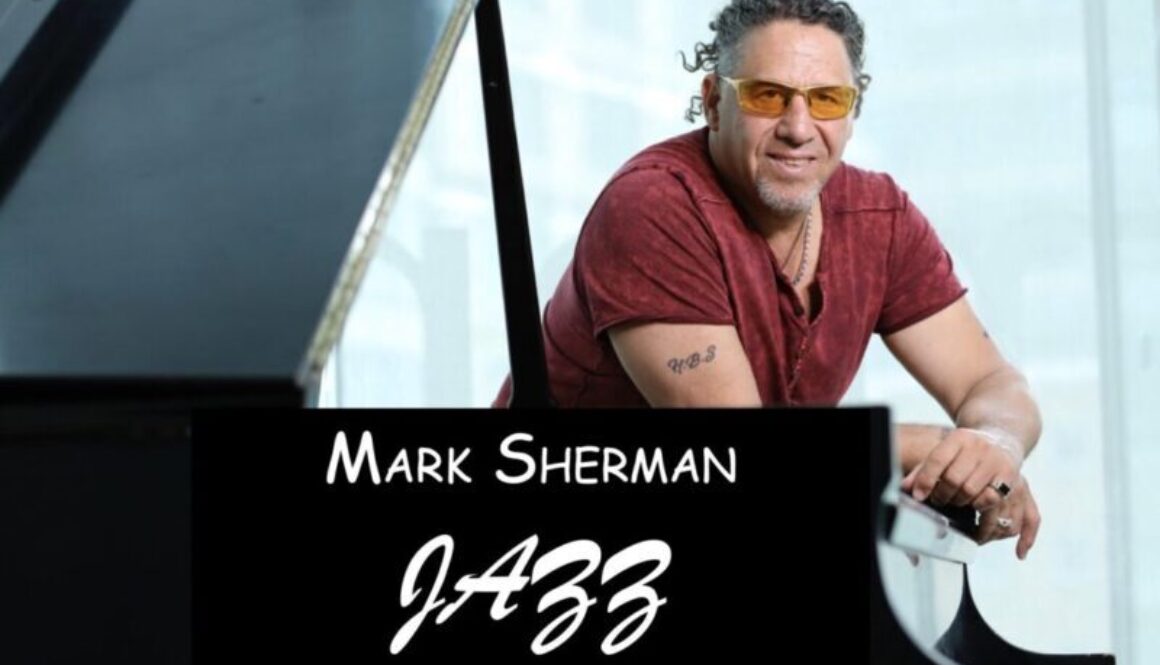 A man sitting at the piano with his arms crossed.