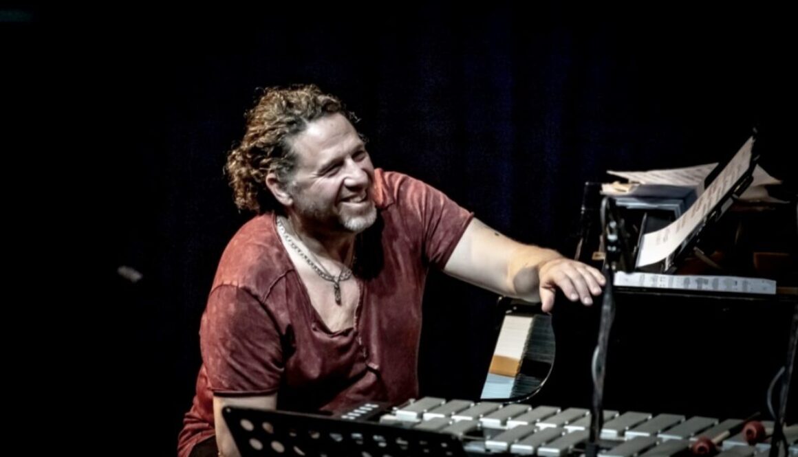 A man sitting at an instrument playing a keyboard.