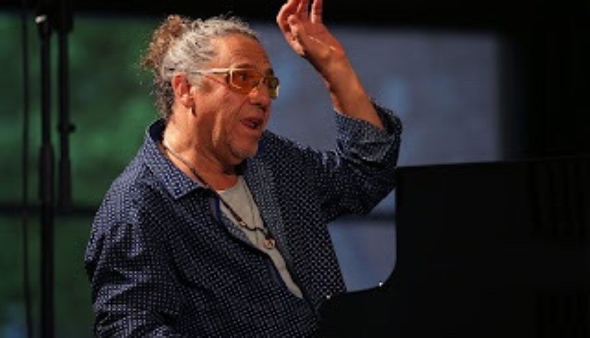 A man with glasses is playing piano