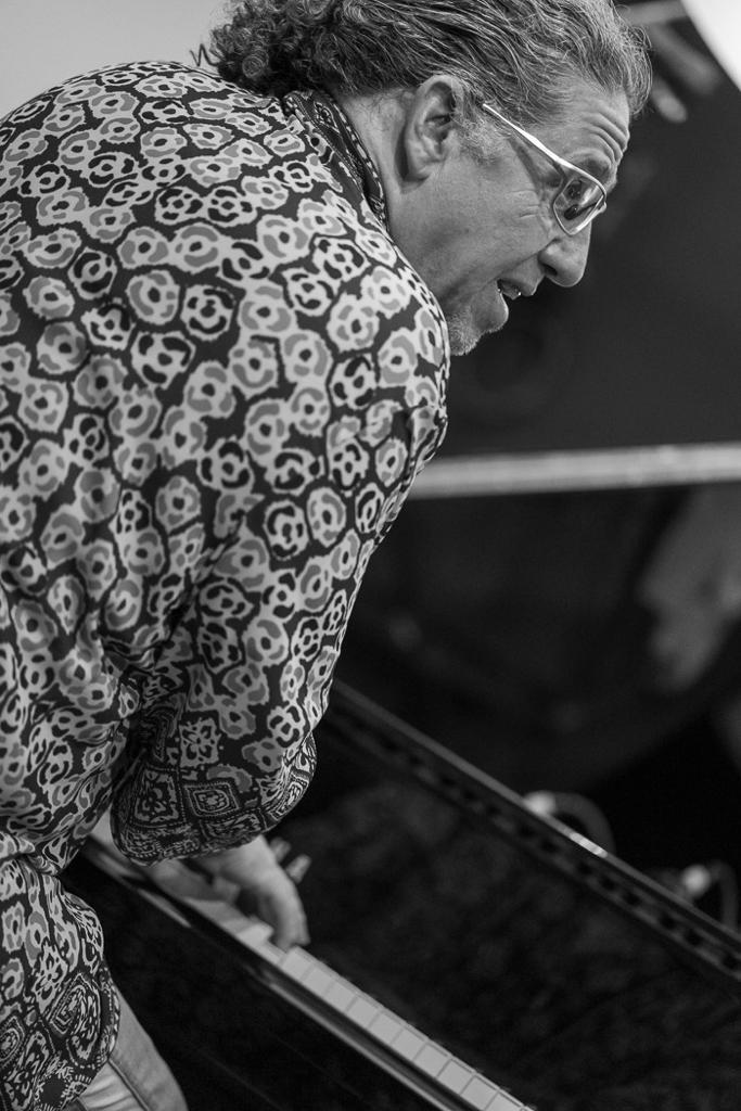 FBE6B6A1-1D05-41E8-BCA9-89B9BAFC7A74 A person in a floral shirt is standing next to a keyboard.
