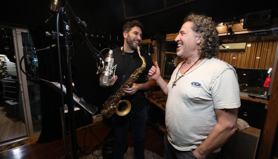 Two men are playing a saxophone in the recording studio.