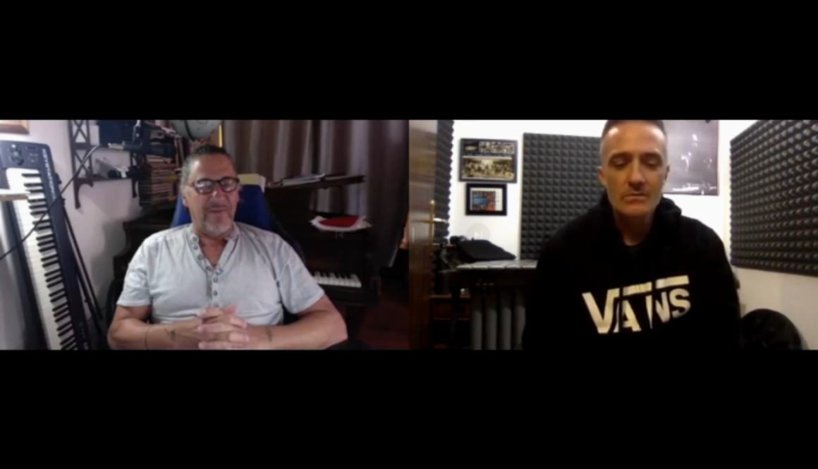 Two men sitting in front of a microphone.