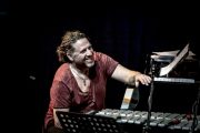 Smiling musician playing vibraphone and piano.